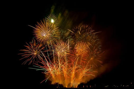 Huge, colorful fireworks over the rice fields at dusk.