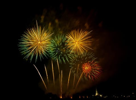 Huge, colorful fireworks over the rice fields at dusk.