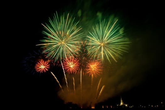 Huge, colorful fireworks over the rice fields at dusk.