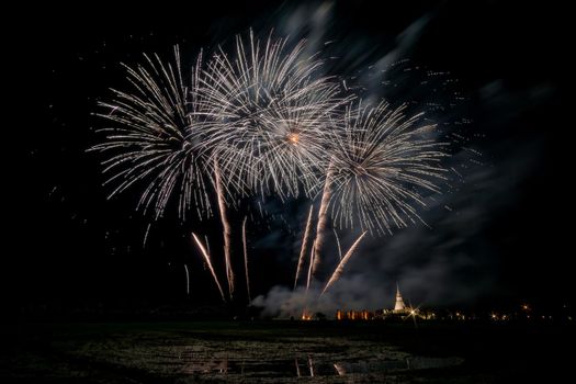 Huge, colorful fireworks over the rice fields at dusk.