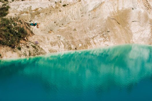 Vaukavysk chalk pits or Belarusian Maldives are beautiful saturated blue lakes.Two tourists pull a boat out of the water Belarus.