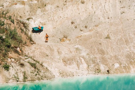 Vaukavysk chalk pits or Belarusian Maldives are beautiful saturated blue lakes.Two tourists pull a boat out of the water Belarus.