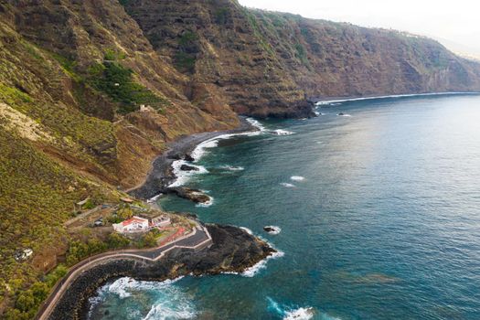 Rough rocky cliffs in the North of Tenerife.Black beach in the Canary Islands. Rocks, volcanic rocks, Atlantic ocean.