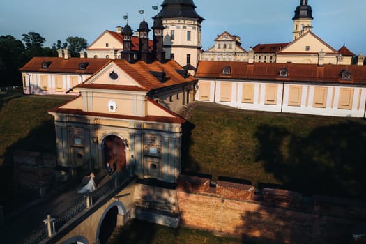 Wedding of newlyweds on the background of the castle in Nesvizh from a height, Minsk region, Belarus.Nesvizh castle, unrecognizable.