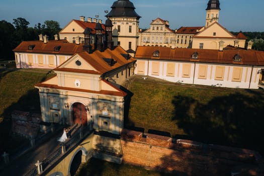 Wedding of newlyweds on the background of the castle in Nesvizh from a height, Minsk region, Belarus.Nesvizh castle, unrecognizable.