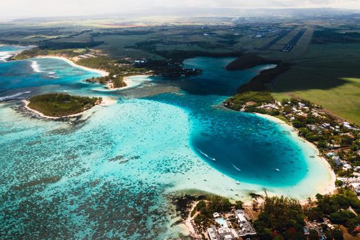 Aerial picture of the east coast of Mauritius Island. Beautiful lagoon of Mauritius Island shot from above. Boat sailing in turquoise lagoon.