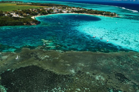 Aerial picture of the east coast of Mauritius Island. Beautiful lagoon of Mauritius Island shot from above. Boat sailing in turquoise lagoon