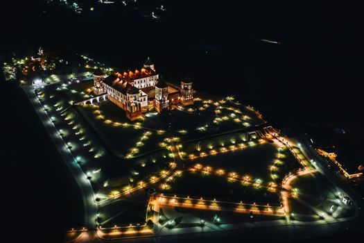 Night Mir castle with spires near the lake top view in Belarus near the city of Mir.
