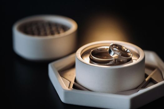 two gold wedding rings in a white box on a black background.