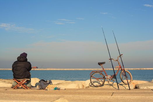 CHIOGGIA, ITALY - JANUARY, 01: Fisher man with fishing rods and bike on January 01, 2016
