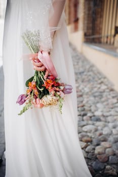 wedding bouquet with peonies in the hands of the bride under the veil.Morning of the bride.