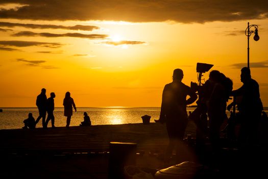 TRIESTE, ITALY - APRIL, 17: Behind the scene. Film crew team filming movie scene on outdoor location at sunset on April 17, 2018