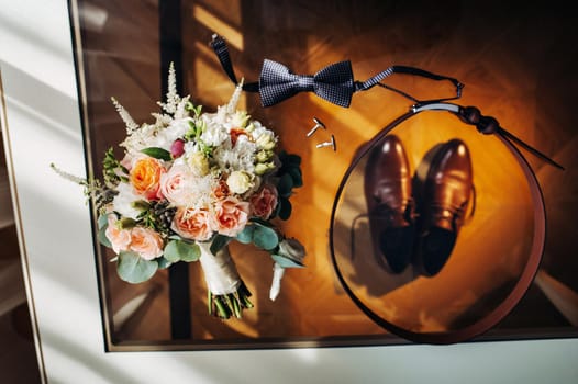 wedding bouquet with roses on the table and a boutonniere.The decor at the wedding.