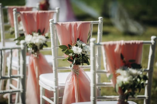 Wedding ceremony on the street on the green lawn.Decor with fresh flowers arches for the ceremony.