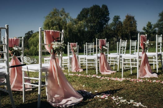 Wedding ceremony on the street on the green lawn.Decor with fresh flowers arches for the ceremony.