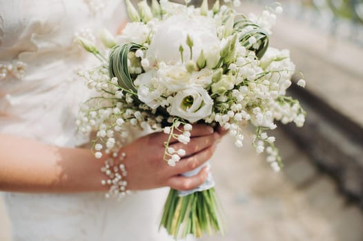 wedding bouquet with peonies in the hands of the bride under the veil.Morning of the bride.