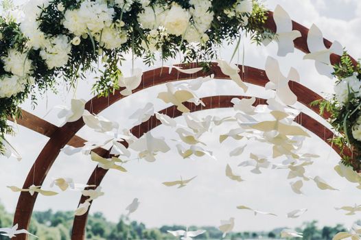 Wedding ceremony on the street on the green lawn.Decor with fresh flowers arches for the ceremony.