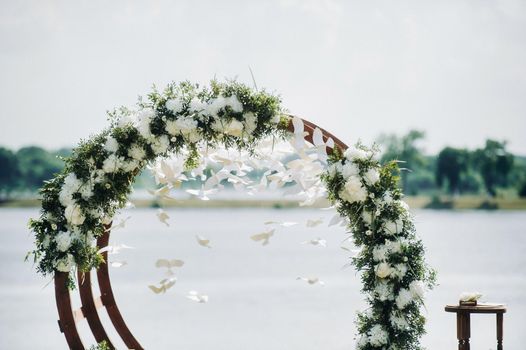 Wedding ceremony on the street on the green lawn.Decor with fresh flowers arches for the ceremony.