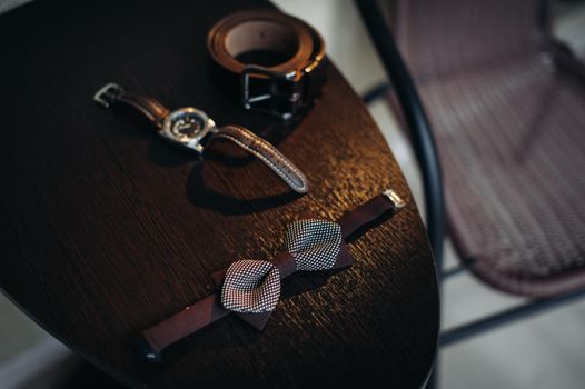 black bow tie on light background and watch.