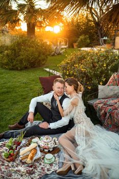 Newlyweds ' dinner on the lawn at sunset.A couple sits and drinks tea at sunset in France.