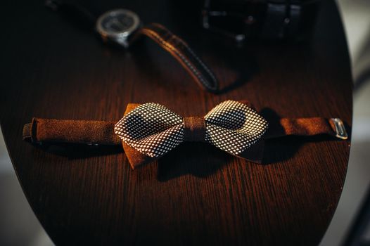 black bow tie on light background and watch.