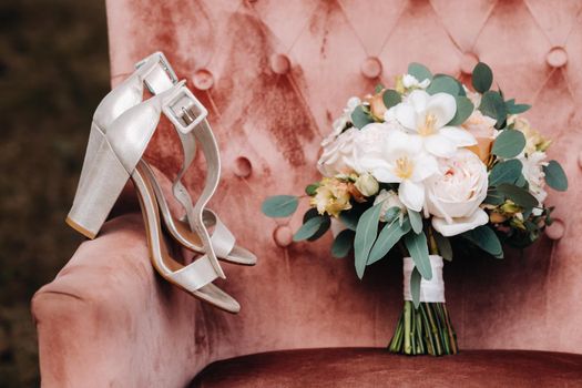 wedding bouquet with peonies and roses on a chair and boutonniere.The decor at the wedding.