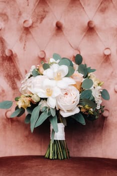 wedding bouquet with roses on the table and a boutonniere.The decor at the wedding.