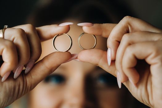 Close-up of two gold wedding rings in your hands.