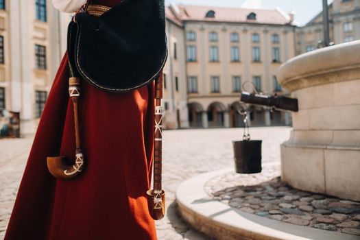 a man in an old red dress close-up on the square in the Nesvizh castle.Nesvizh castle, Belarus.