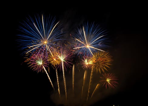 Huge, colorful fireworks over the rice fields at dusk.