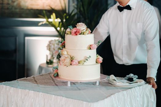 Elegant wedding cake at the wedding in three tiers.