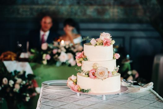 Elegant wedding cake at the wedding in three tiers.