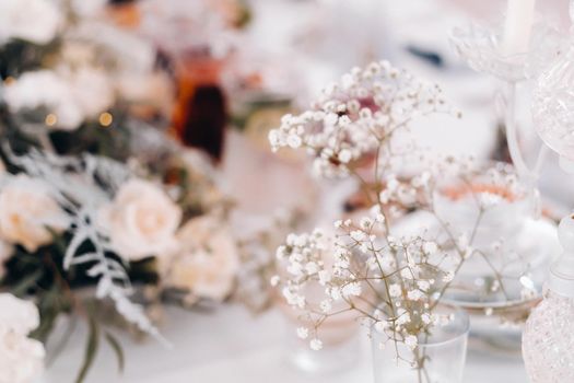 decoration with fluffy flowers on the table in winter style at the wedding.