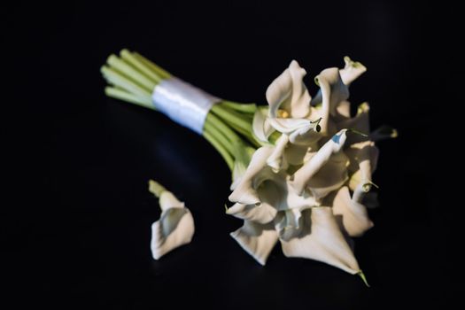 Wedding bouquet of white Calla lilies on a black background.