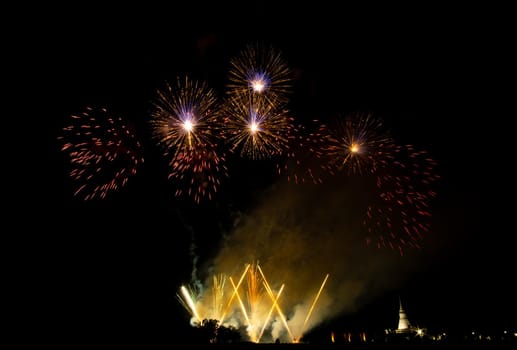 Huge, colorful fireworks over the rice fields at dusk.