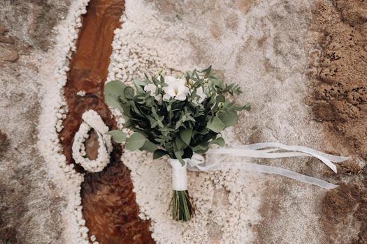 the wedding bouquet rests on a salty texture.The decor at the wedding.