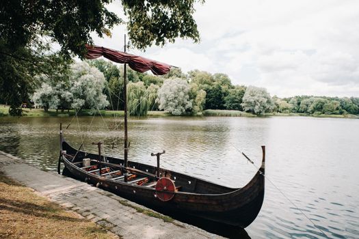 An antique Viking ship on the river. Old boat.