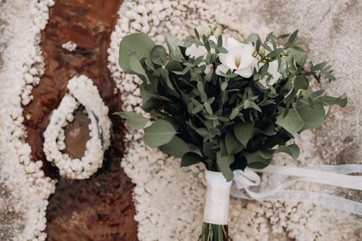 the wedding bouquet rests on a salty texture.The decor at the wedding.