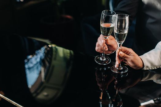 A man and a woman hold champagne glasses in their hands close-up.