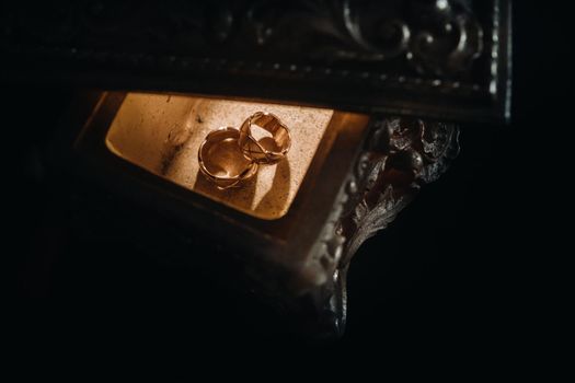 Gold wedding rings lie on an antique jewelry box. Wedding rings for ceremonies.