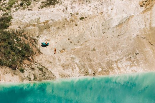 Vaukavysk chalk pits or Belarusian Maldives are beautiful saturated blue lakes.Two tourists pull a boat out of the water Belarus.