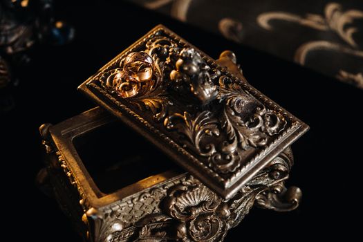 Gold wedding rings lie on an antique jewelry box. Wedding rings for ceremonies.