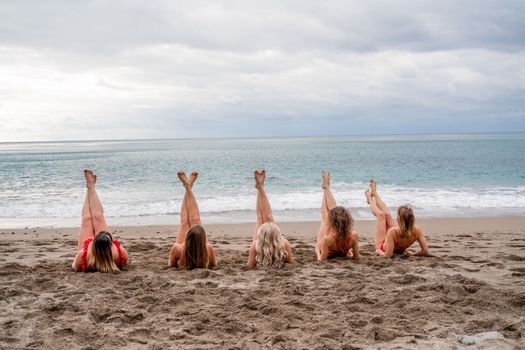 Big happy family or group of five friends is having fun against sunset beach. Beach holidays concept