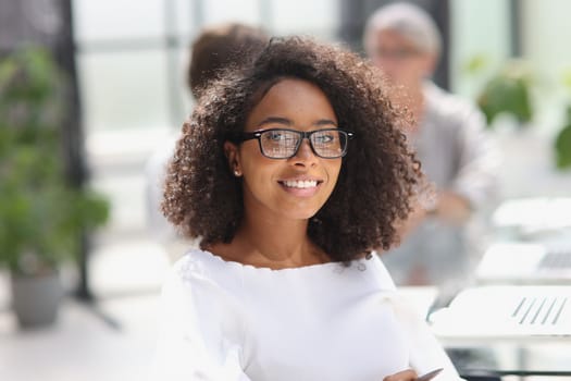 young attractive african american woman in the office sitting at the table