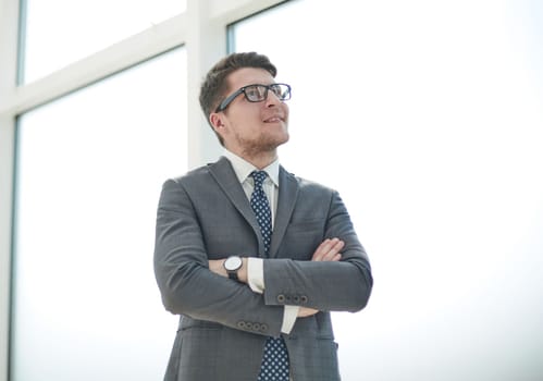 Portrait of a young businessman wearing glasses and standing in office