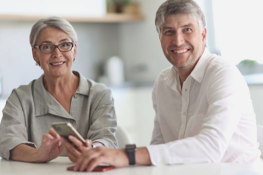 business woman and business man smiling while sitting at the table.