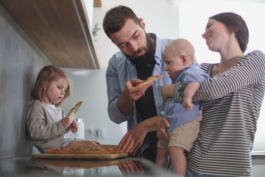 Young family with daughter and son in the kitchen