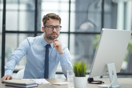 Young cheerful businessman working at office