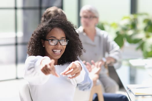 Young business woman sits at the table and rejoices in success.