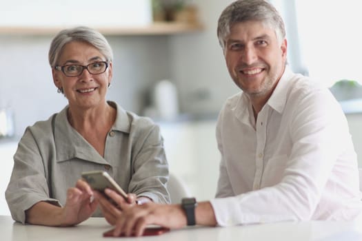 business woman and business man smiling while sitting at the table.